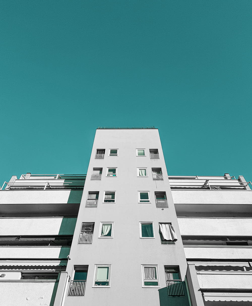 a tall white building with balconies and windows