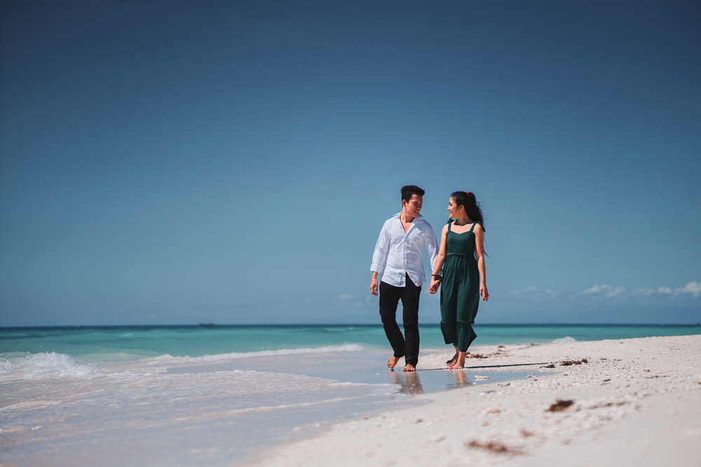 a man and a woman walking on the beach