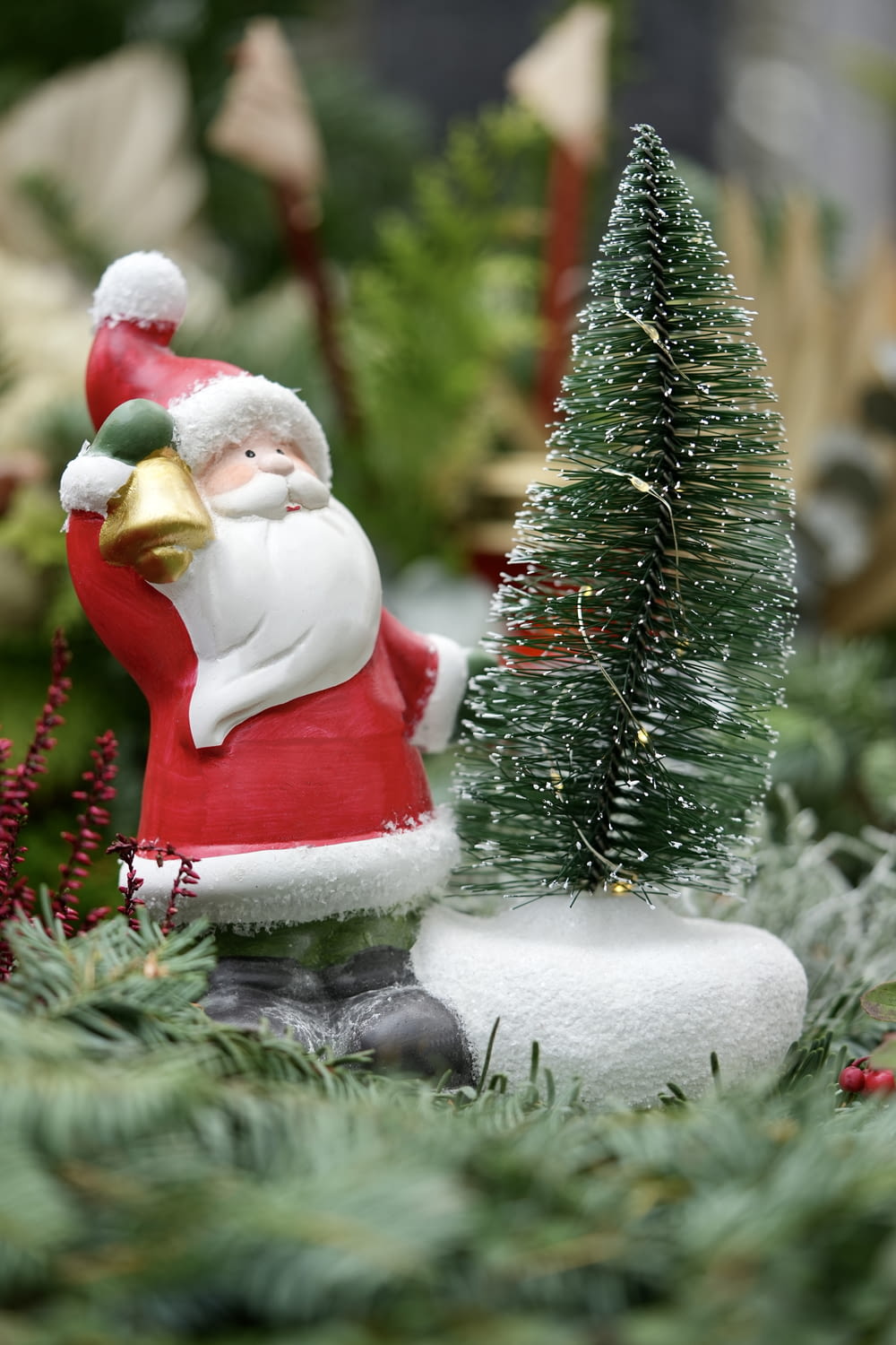 Una figura de Santa Claus junto a un árbol de Navidad