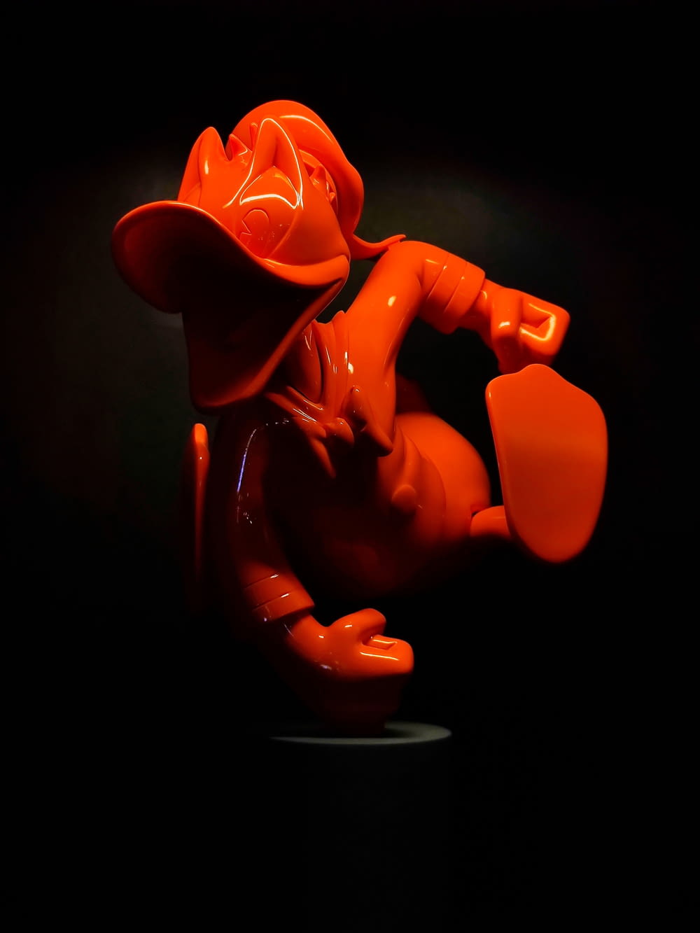an orange toy is posed in the dark