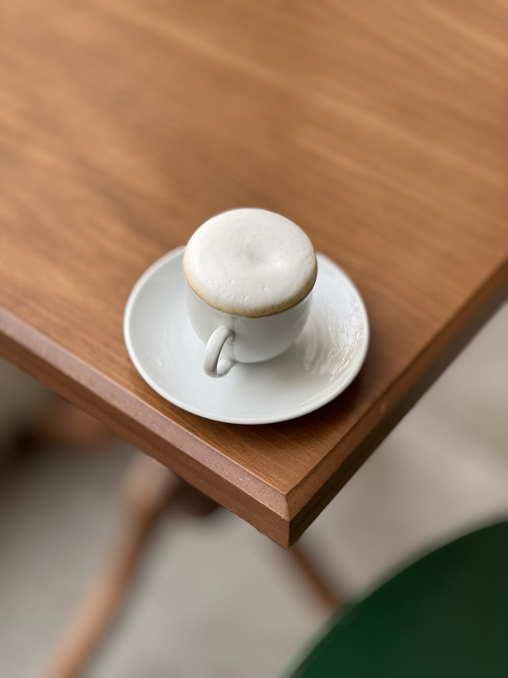 a cappuccino sitting on a saucer on a wooden table
