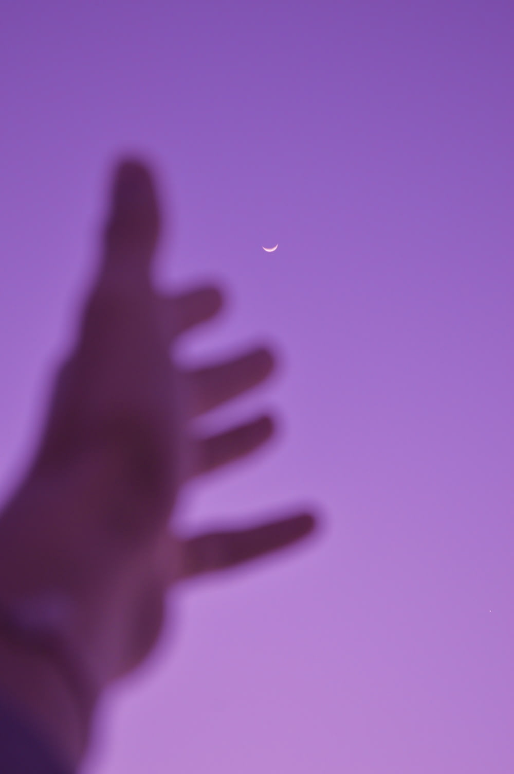 Una foto borrosa de la mano de una persona con una media luna en el