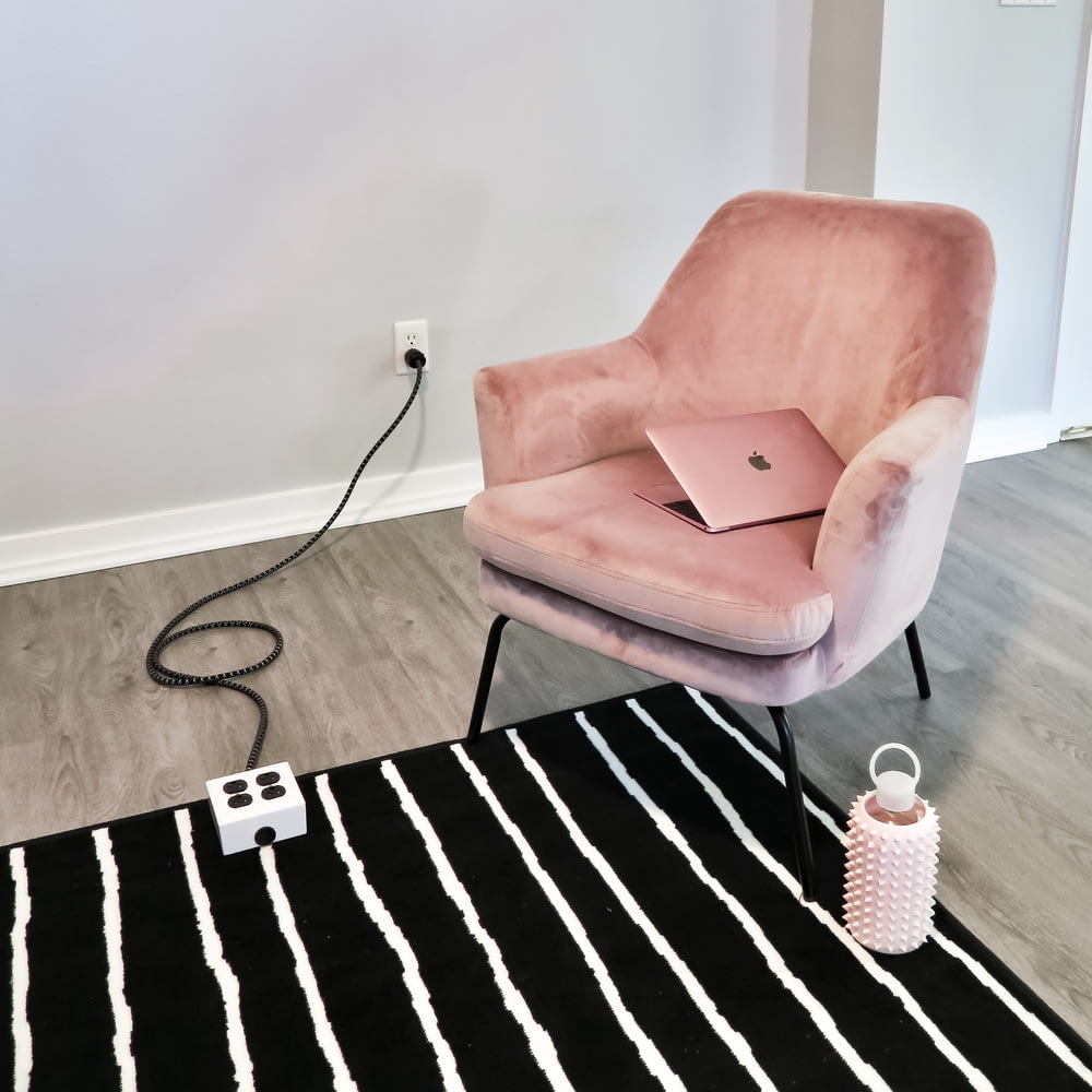 a pink chair with a laptop on top of it