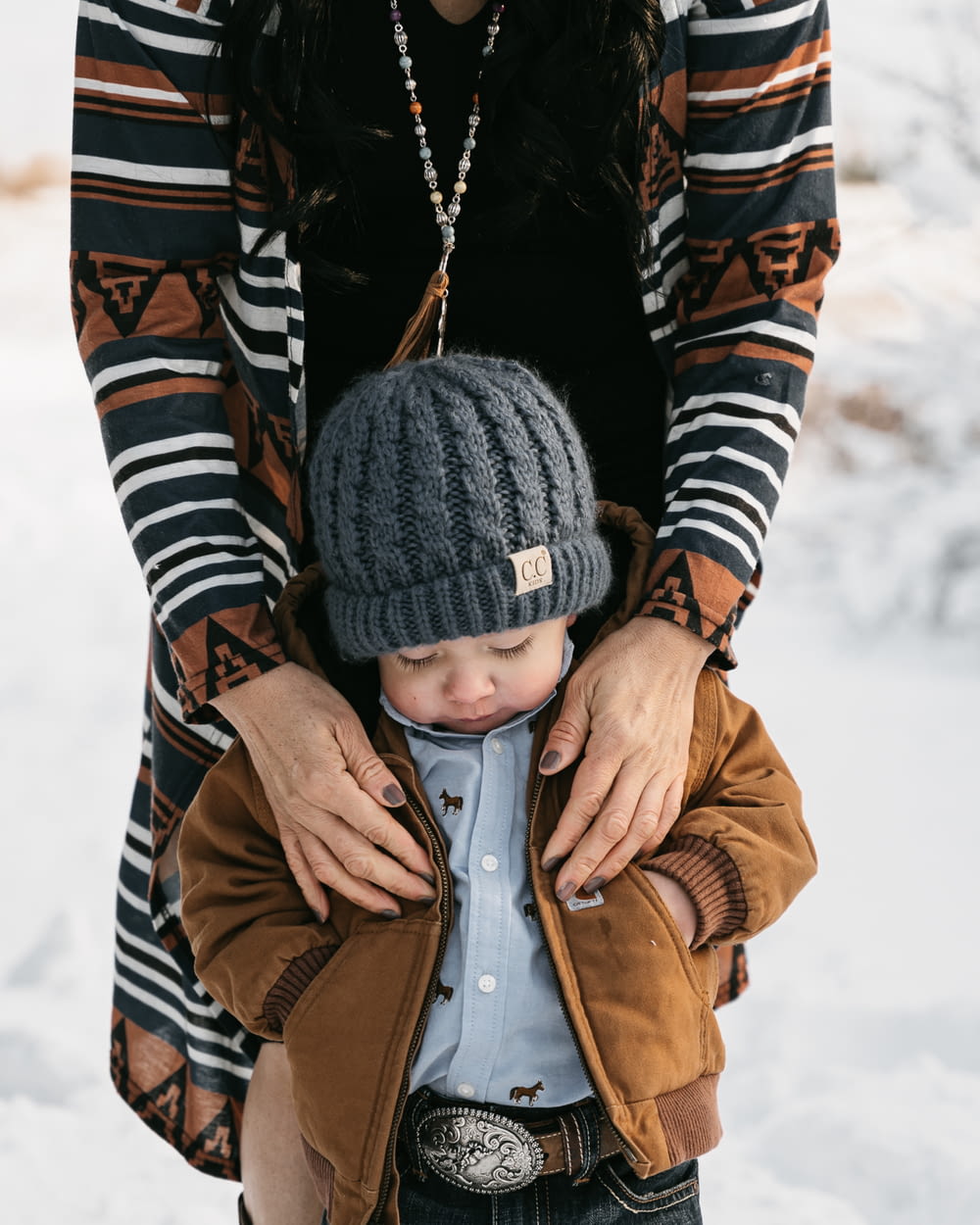 a woman holding a small child in the snow