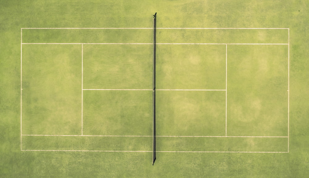 an overhead view of a tennis court with a tennis ball and racket