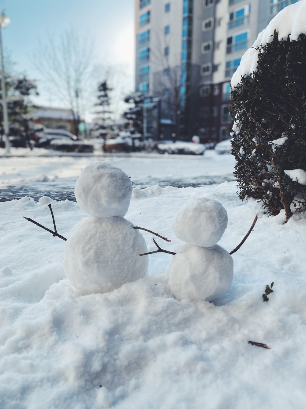 um par de bonecos de neve que estão na neve