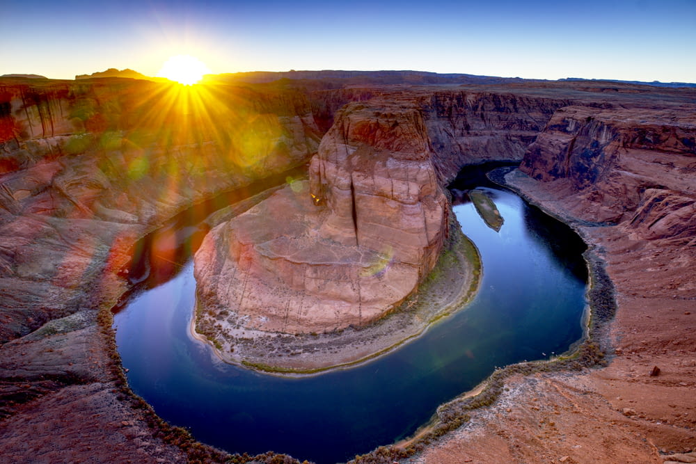 Die Sonne geht über einem Fluss in der Wüste unter