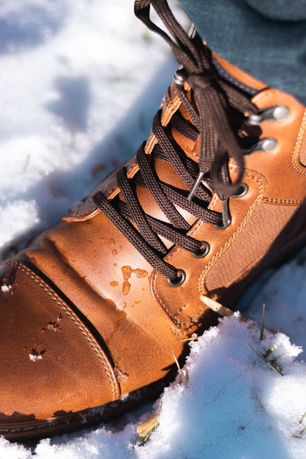 a person standing in the snow wearing a pair of brown shoes