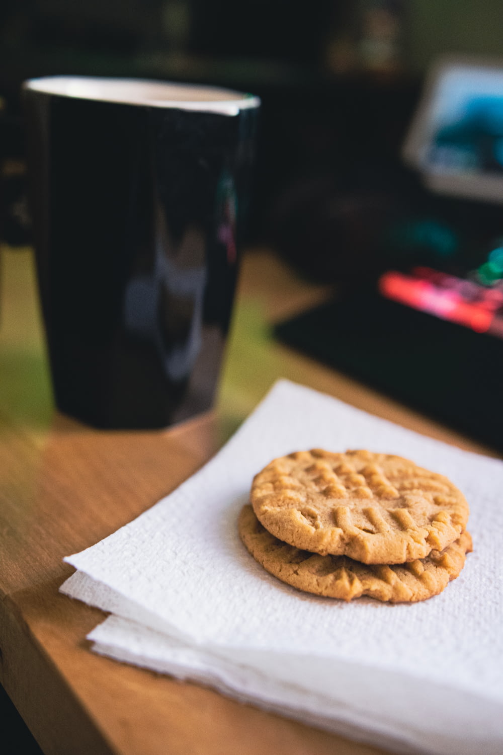 a cookie on a napkin next to a cup of coffee