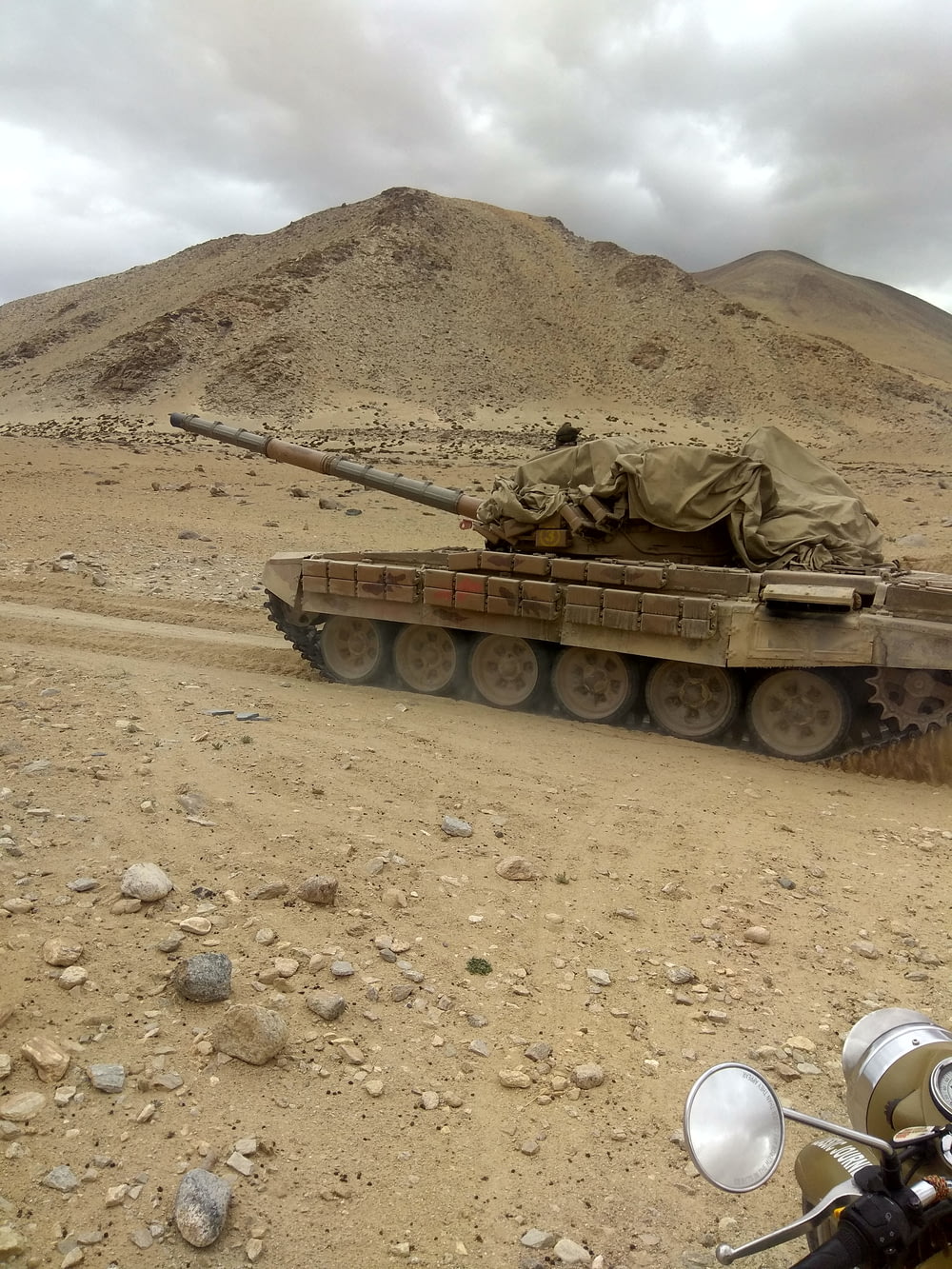 a military tank driving down a dirt road