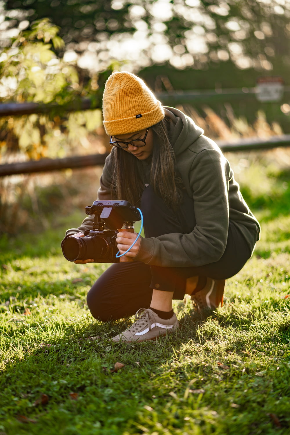 a woman kneeling down while holding a camera