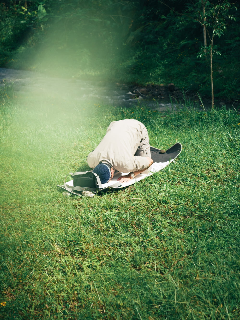 a man laying on top of a surfboard on top of a lush green field