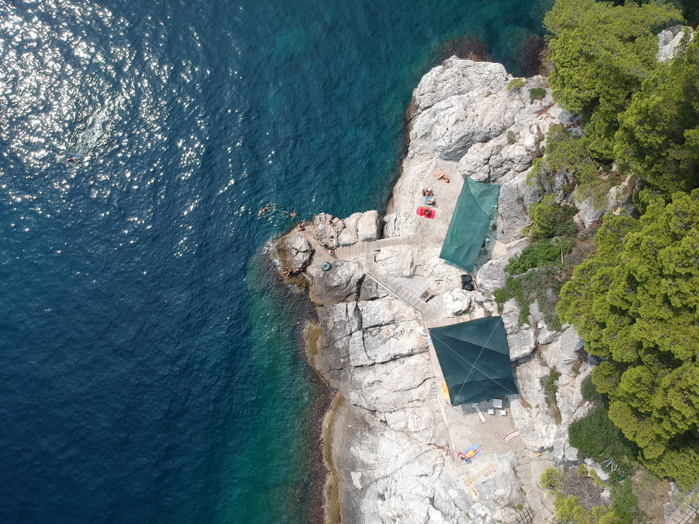 an aerial view of a tent set up on a rocky cliff next to the ocean