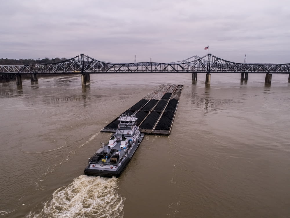 a barge is traveling down the river under a bridge