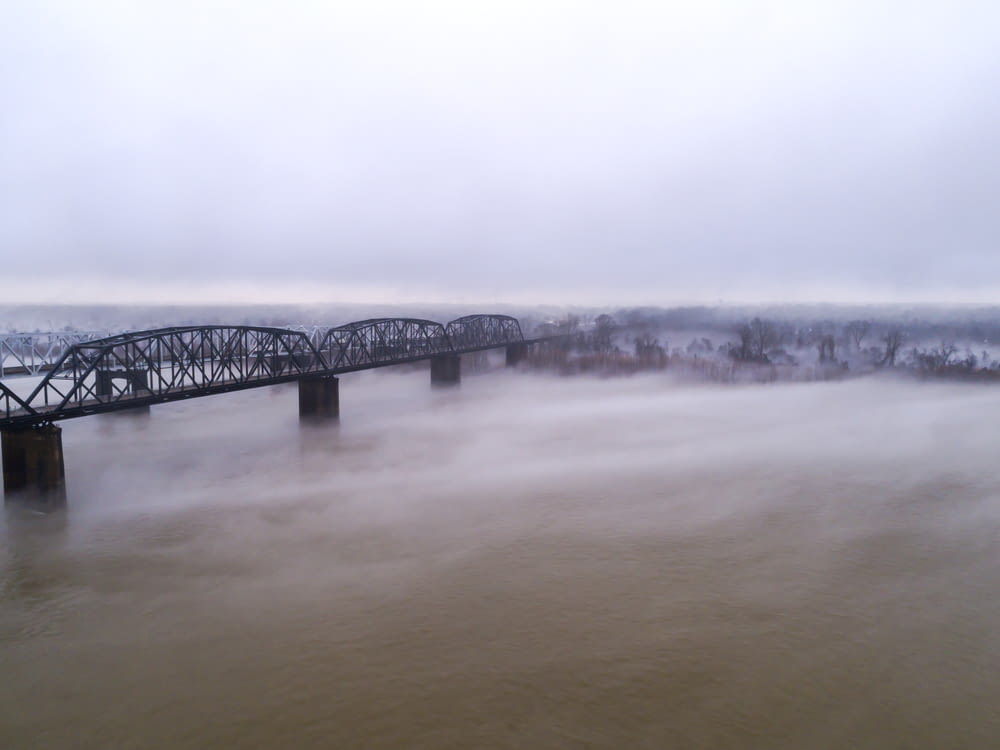 a bridge over a body of water on a foggy day