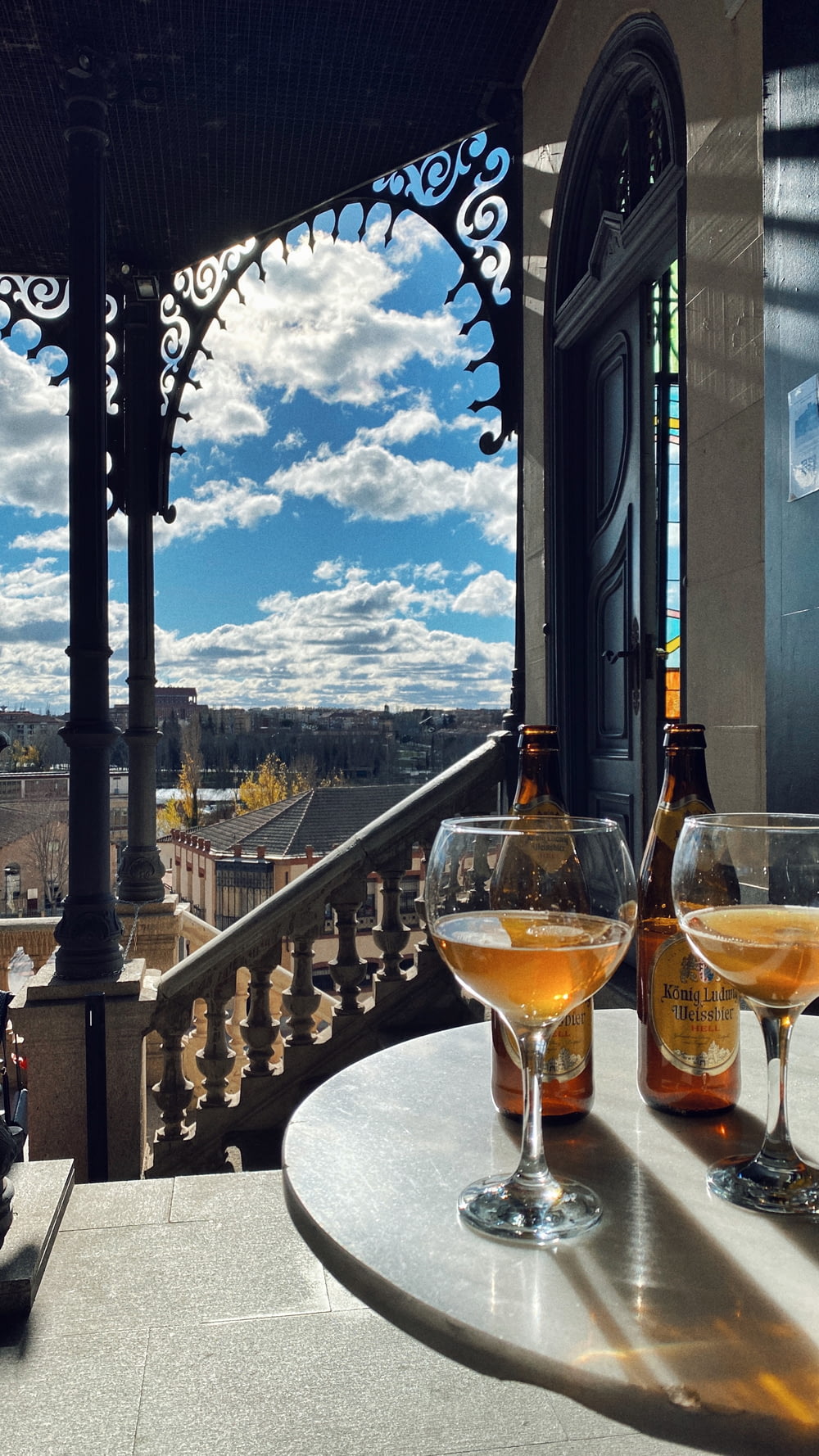 two glasses of wine on a table with a view of the city