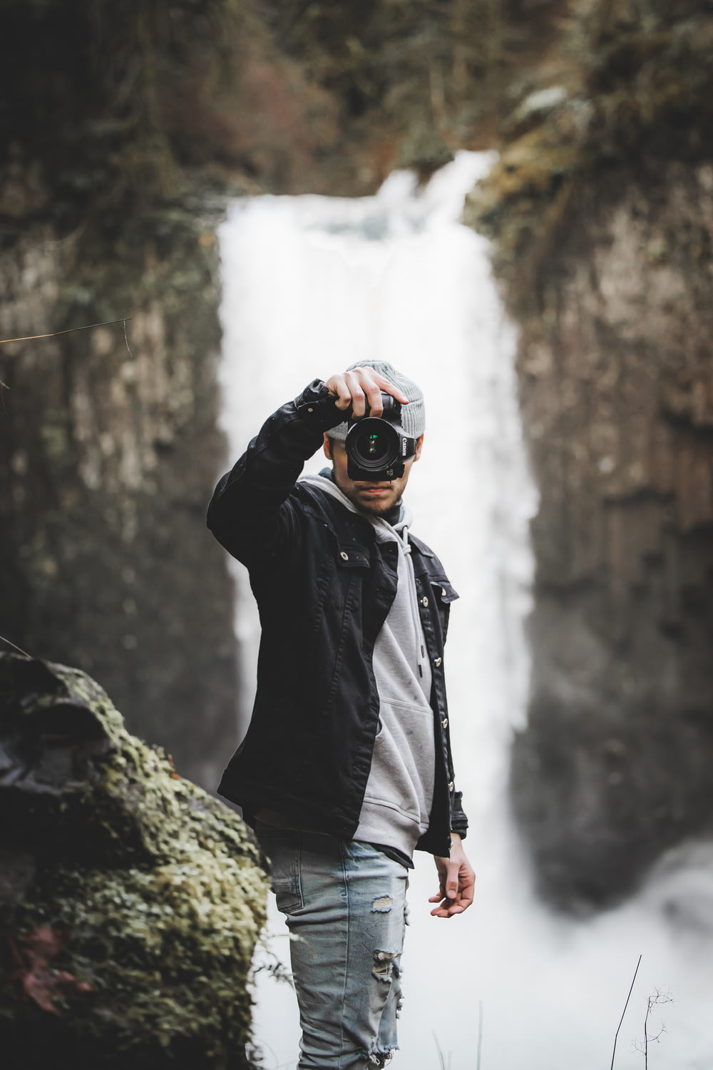 a man taking a picture of a waterfall
