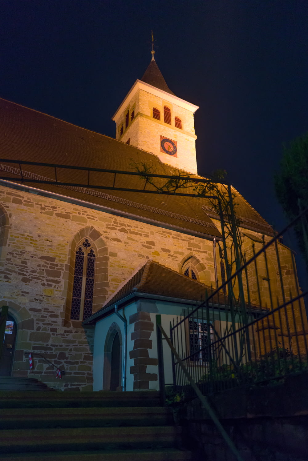 a church with a steeple lit up at night