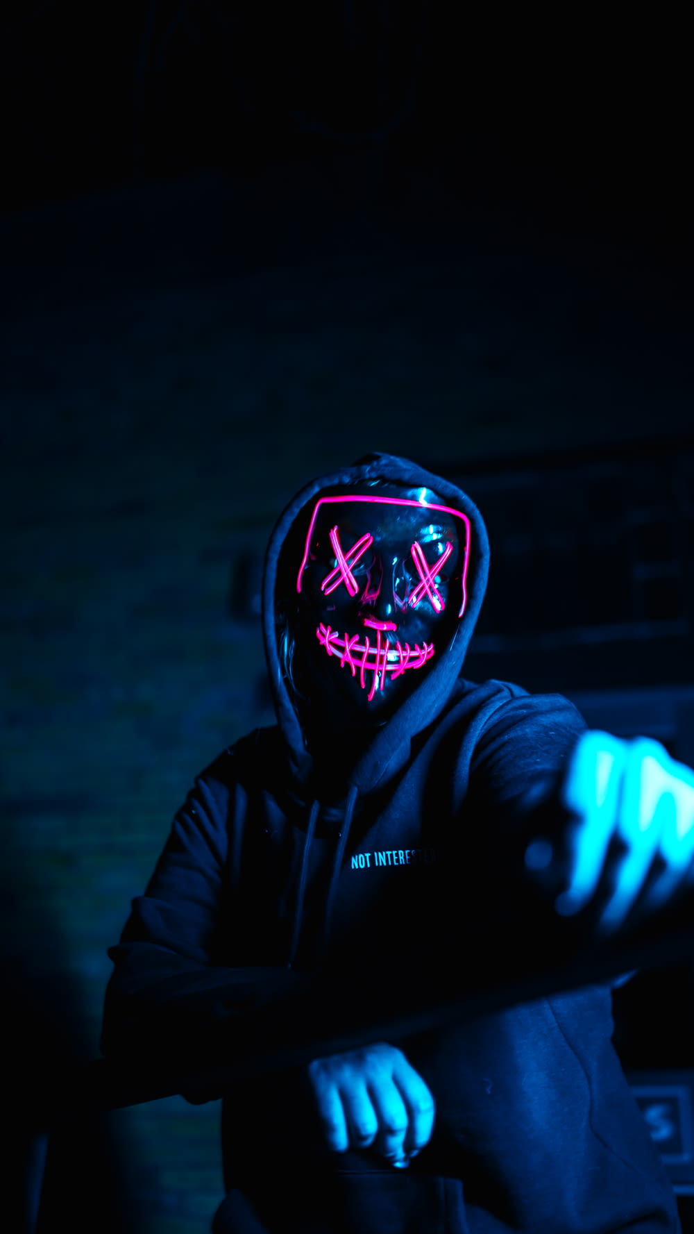 a man wearing a neon mask and holding a baseball bat