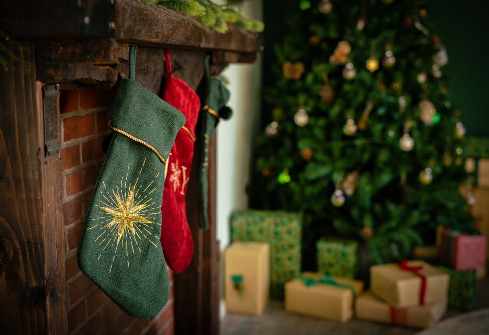 a christmas stocking hanging from a fireplace next to a christmas tree