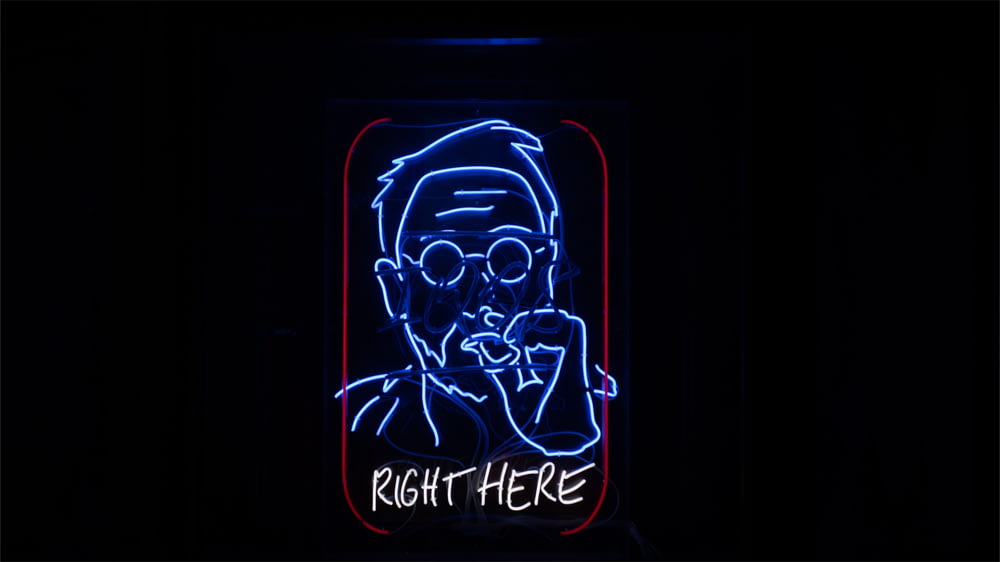 a neon sign with a picture of a man smoking a cigarette