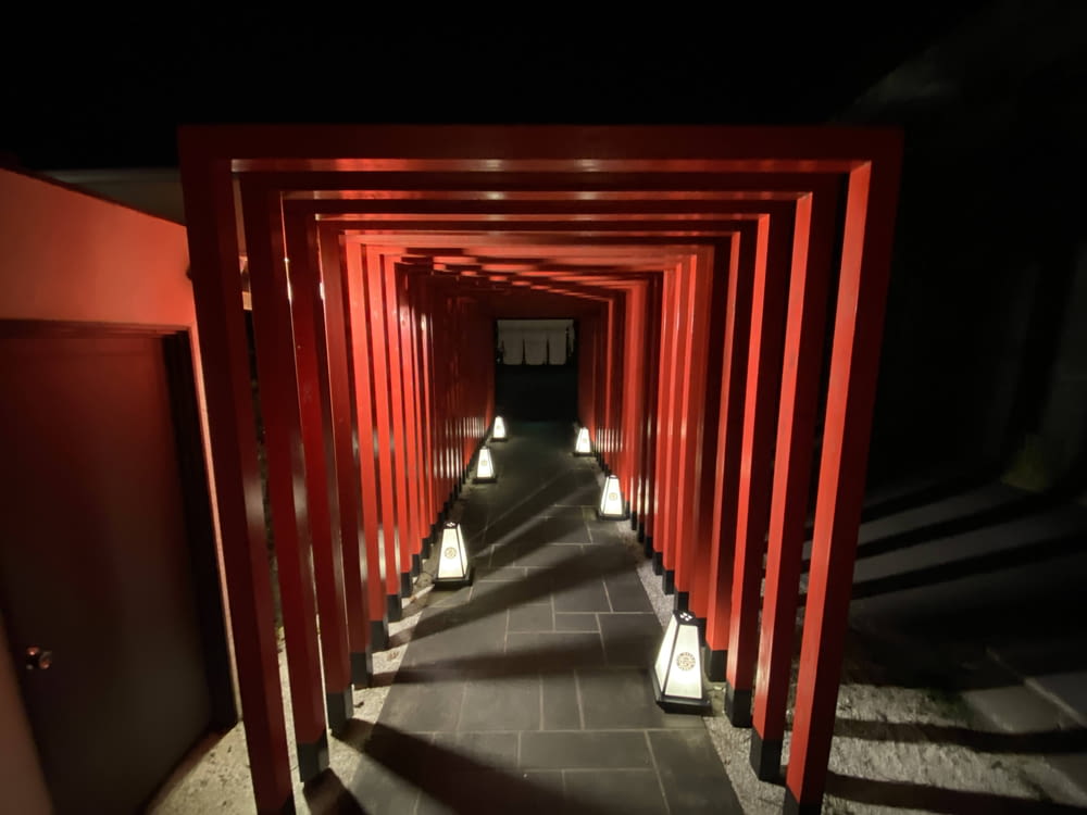 a tunnel of red pillars with lights on them