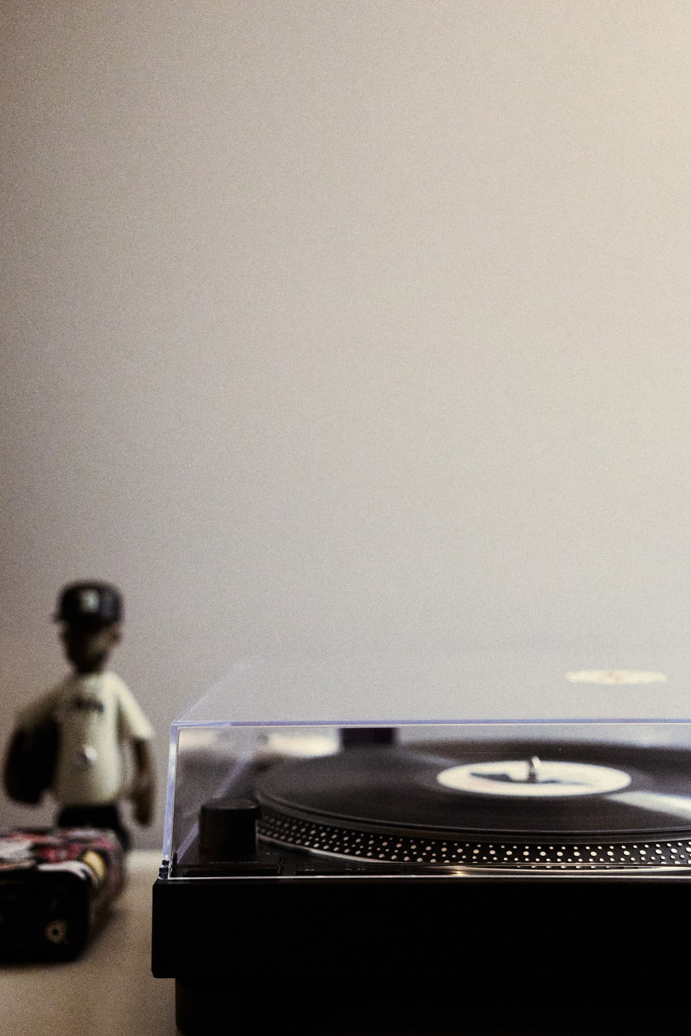 a record player sitting next to a figurine on a table