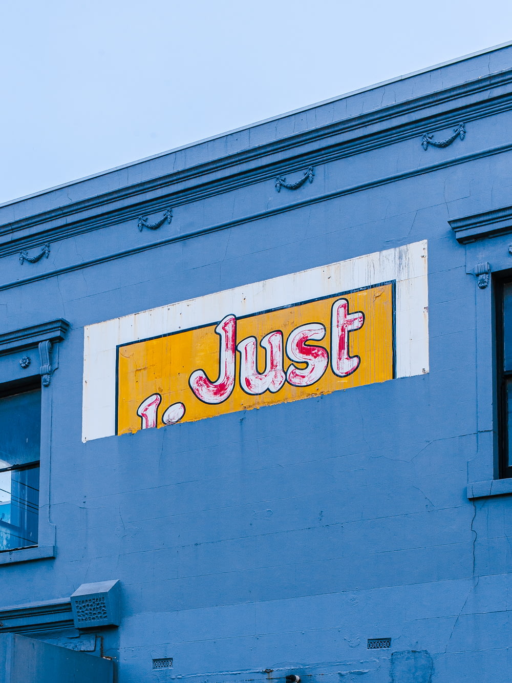 a sign on the side of a building that says just
