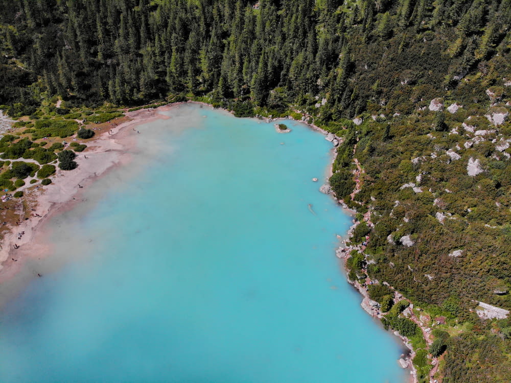 an aerial view of a blue lake surrounded by trees