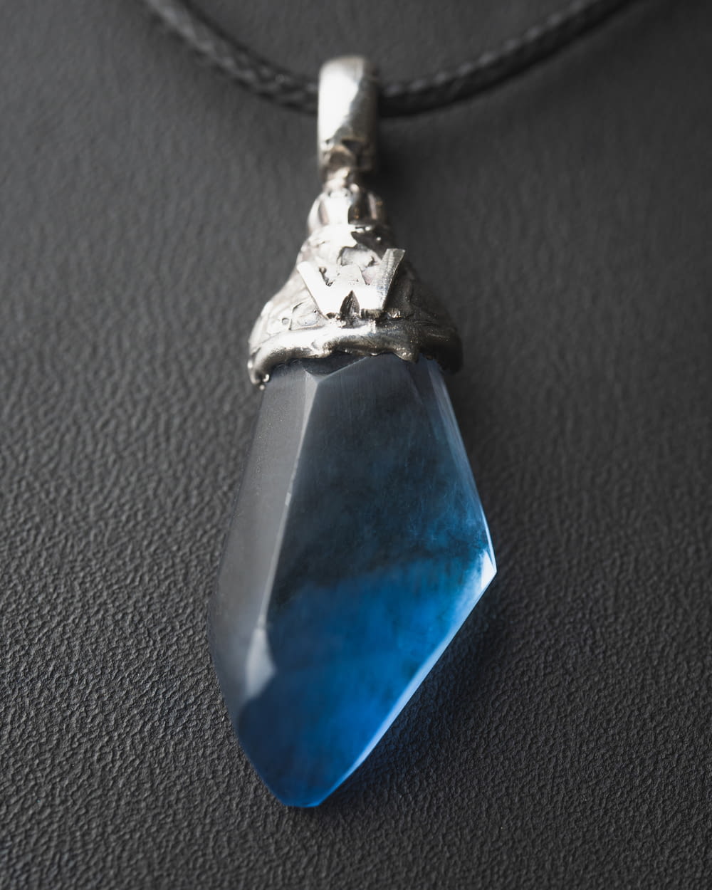 a necklace with a blue stone hanging from it