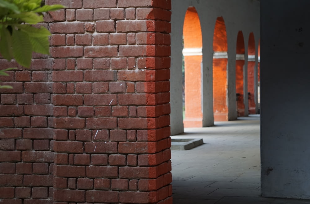 un mur de briques rouges avec des arches en arrière-plan