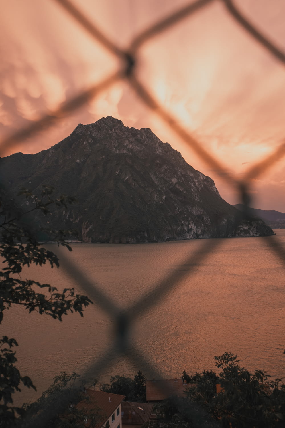 a view of a lake through a chain link fence