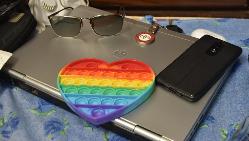 a laptop with a rainbow heart on top of it