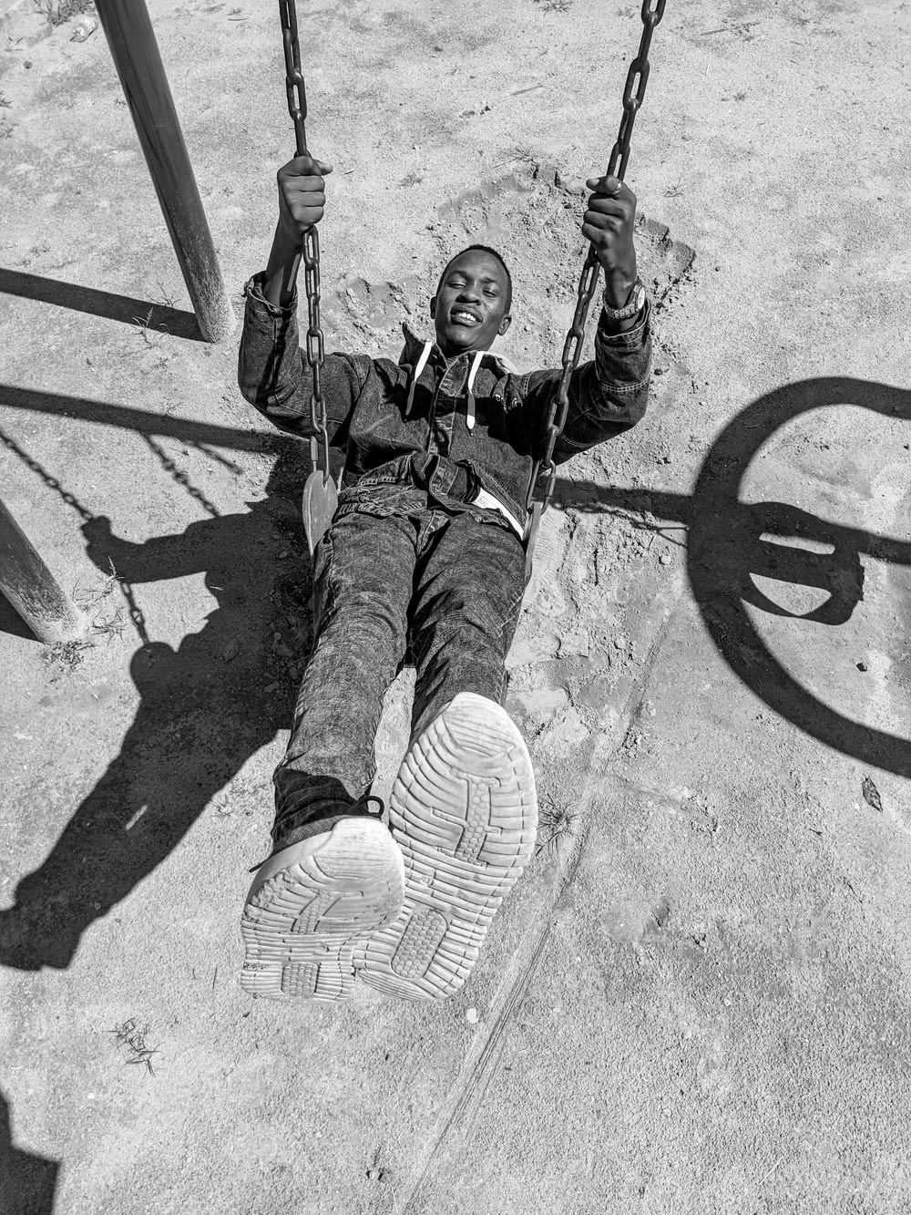 a man sitting on a swing in a playground