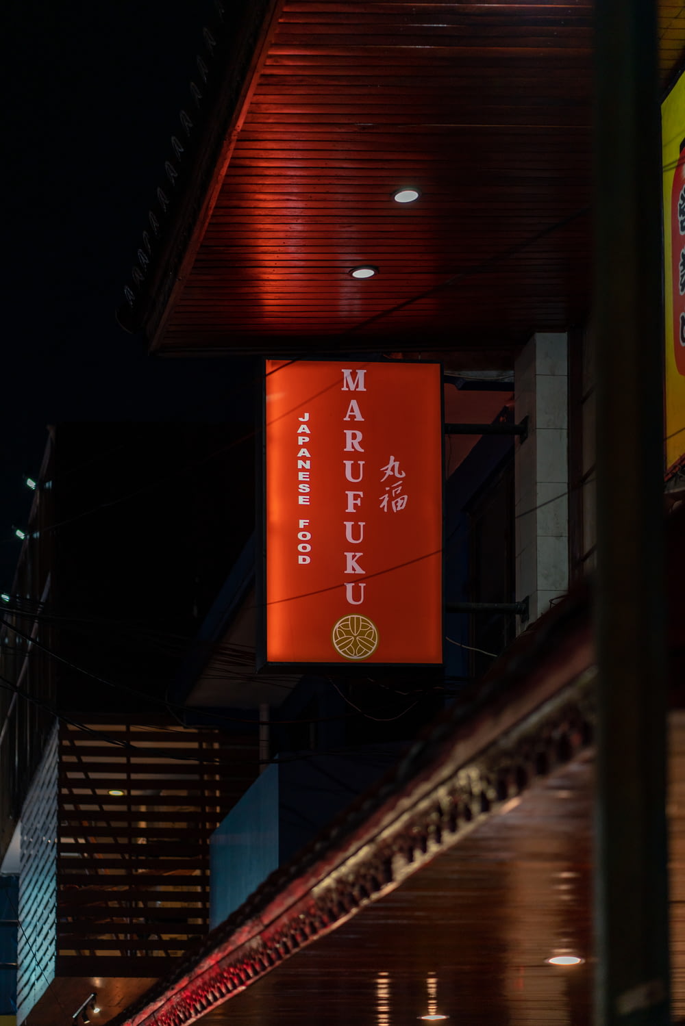 a large orange sign hanging from the side of a building