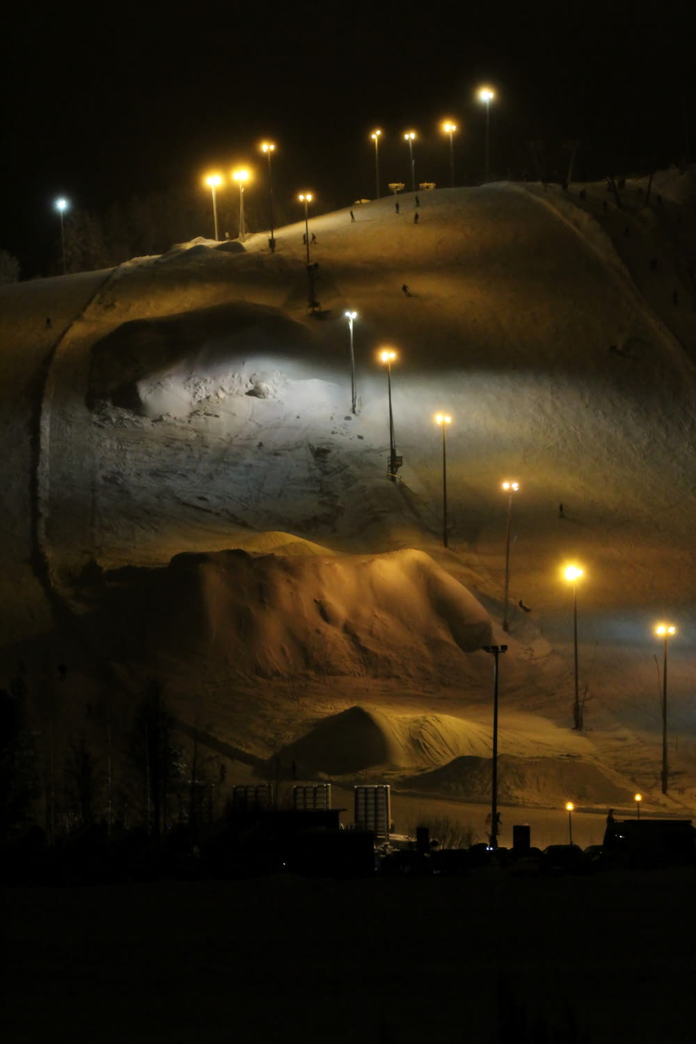 a snow covered hill at night with street lights