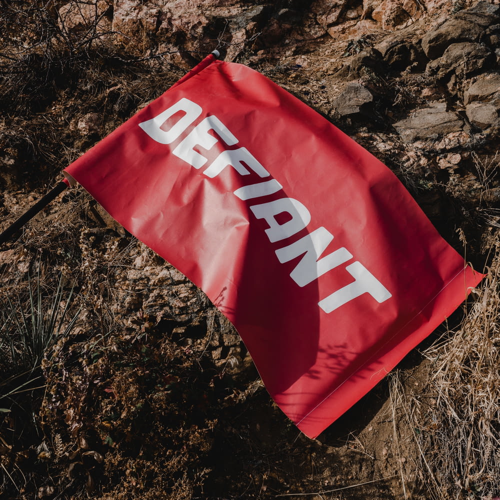 a red flag laying on top of a dirt field