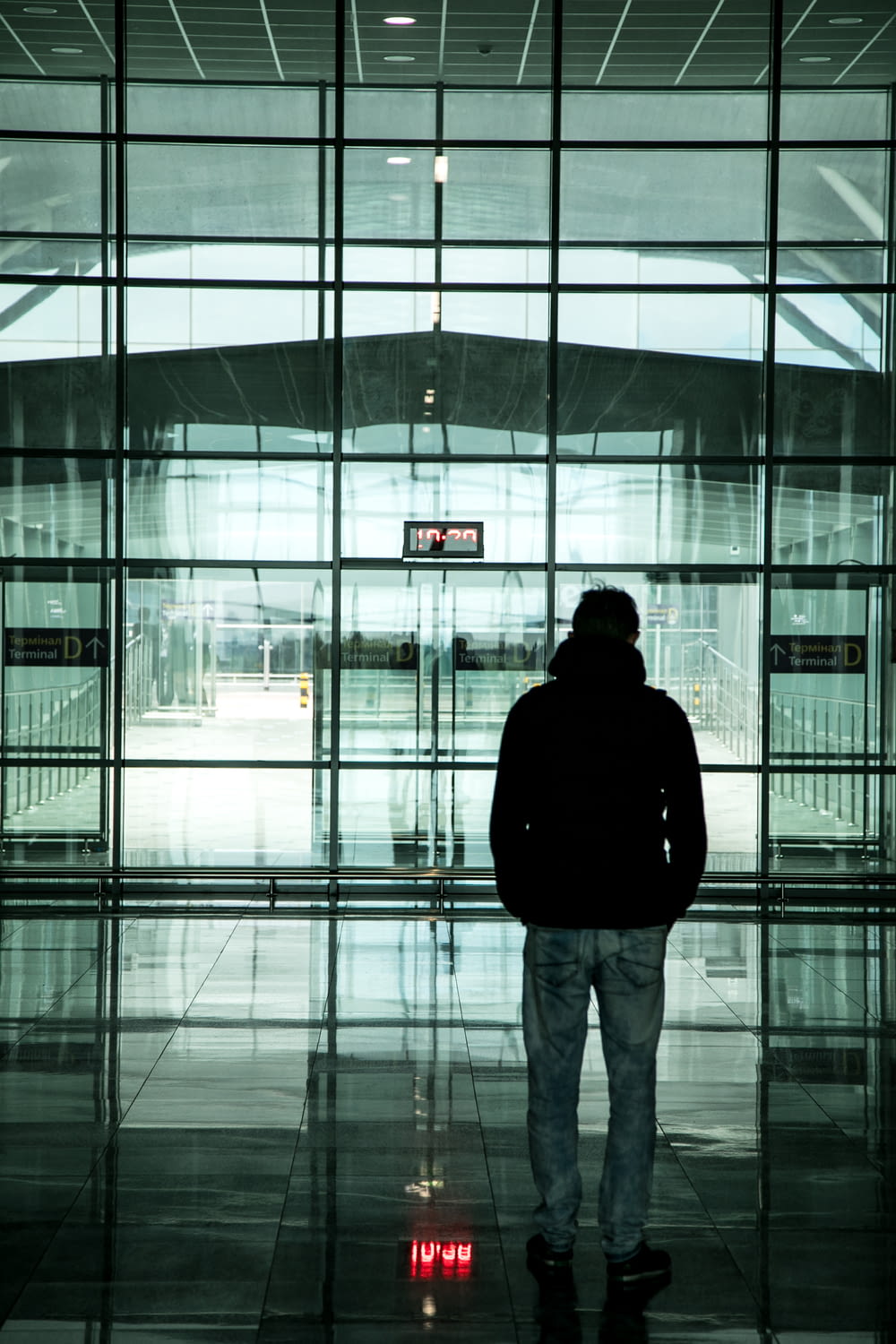 a man standing in front of a large glass building