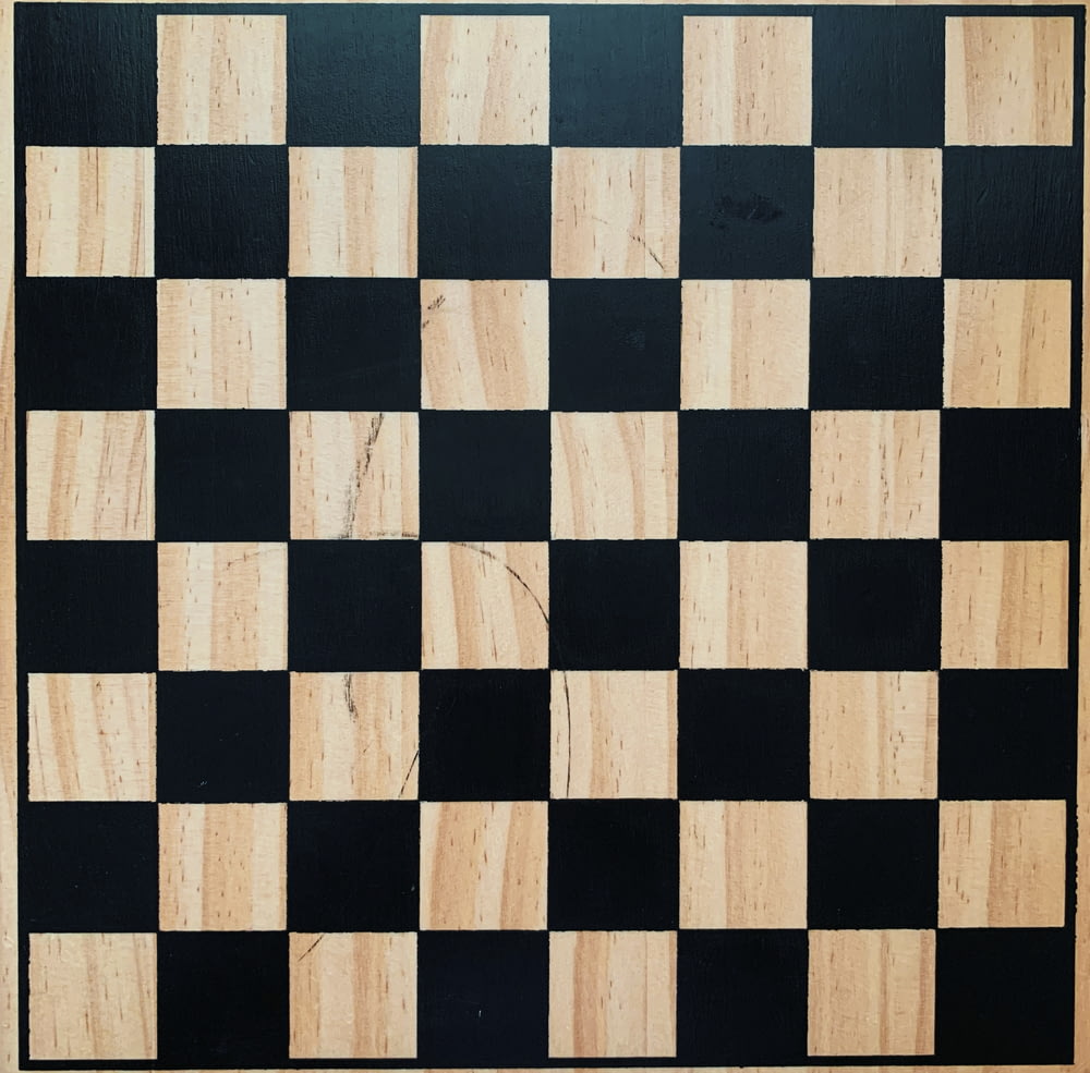 a black and white checkered board with a wooden frame
