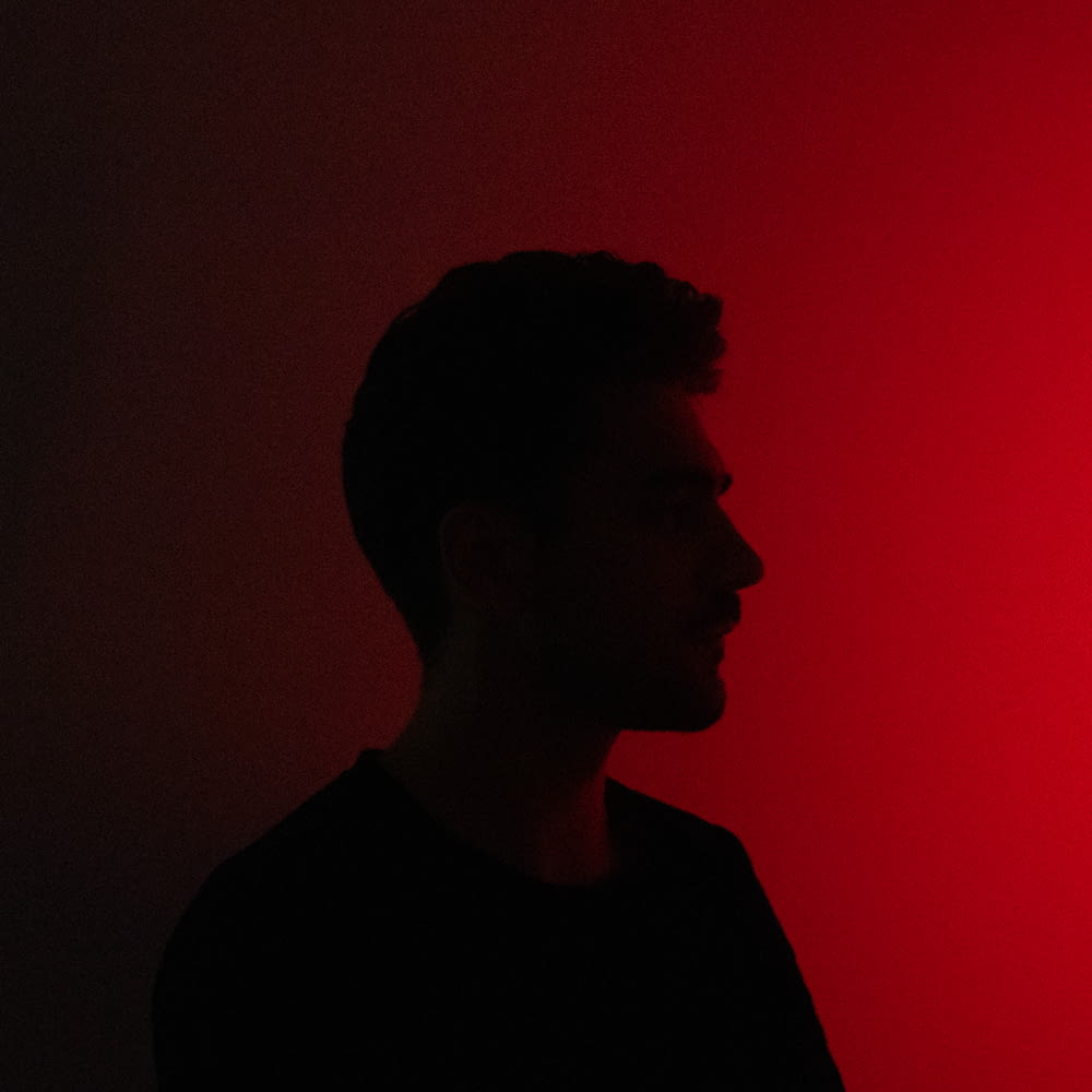 a man standing in front of a red light