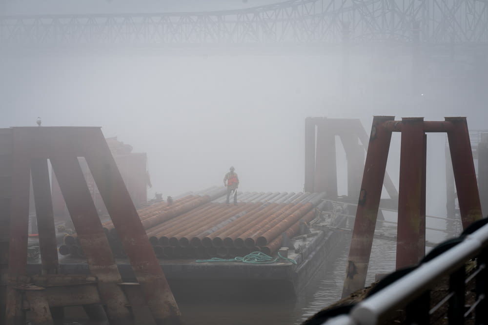 a man standing on a dock in the fog