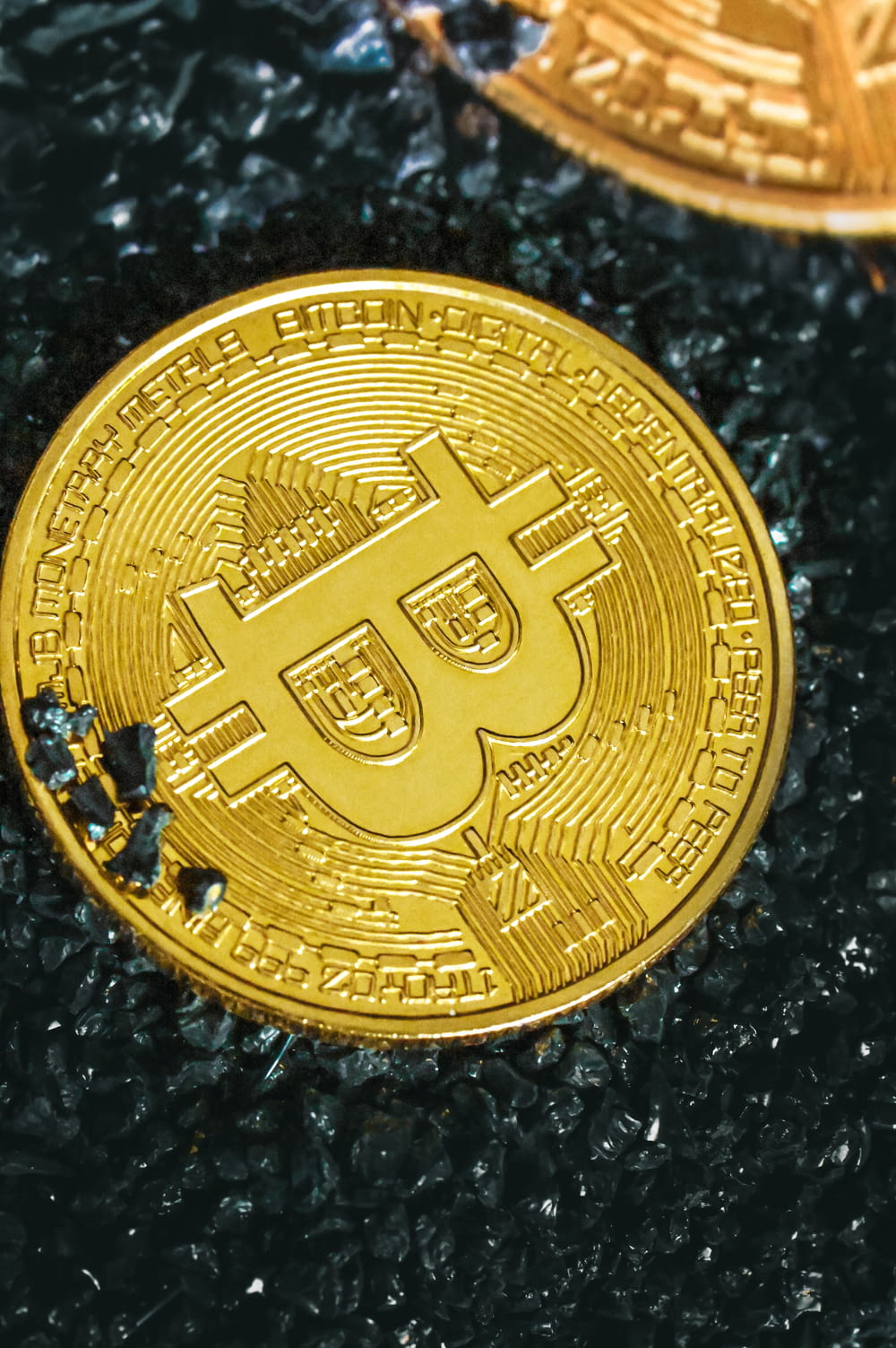 two gold bitcoins sitting on top of each other