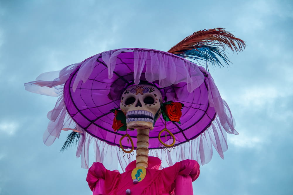 a skeleton wearing a purple hat with feathers