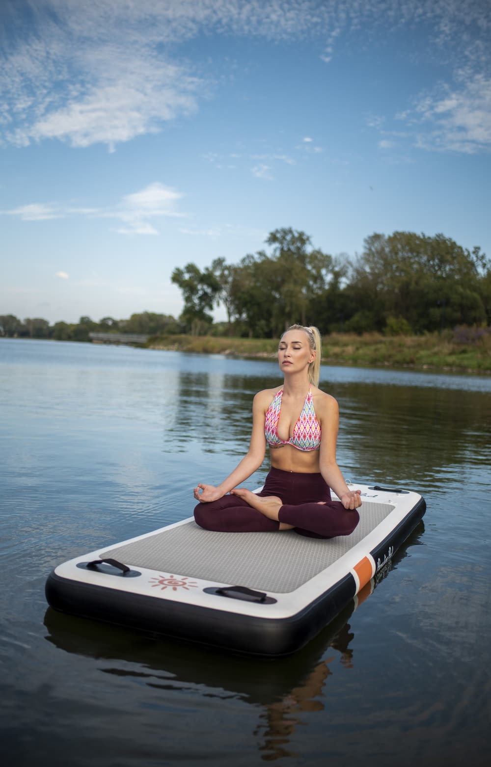 a woman in a bikini top is sitting on a floating device