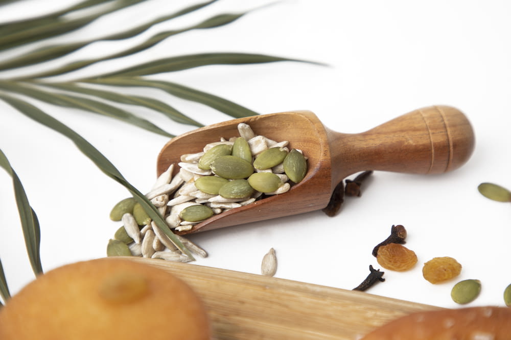 a wooden spoon filled with nuts and seeds