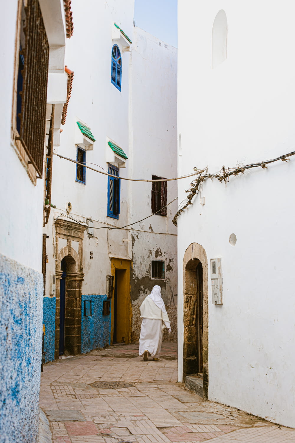 a person in a white robe walking down a street