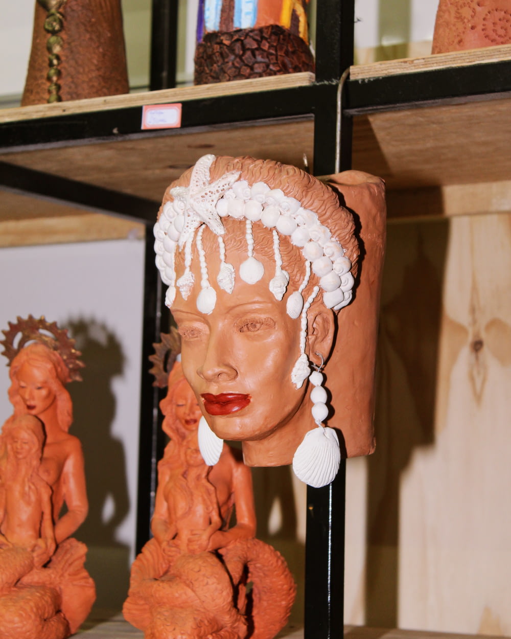a shelf with clay sculptures of women on it
