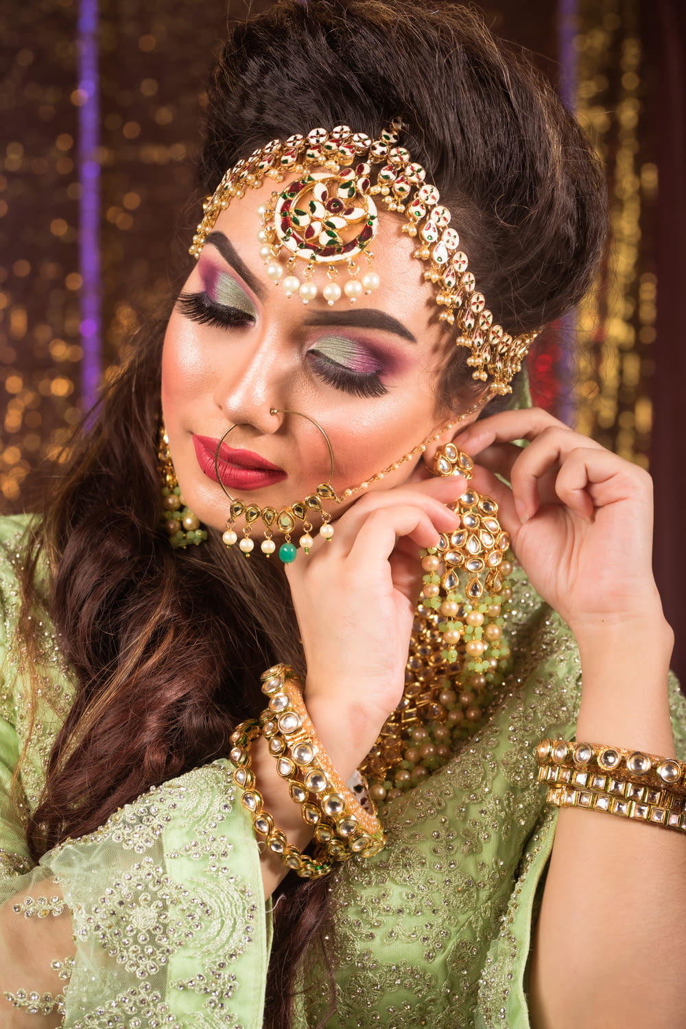 a woman in a green outfit with a gold head piece