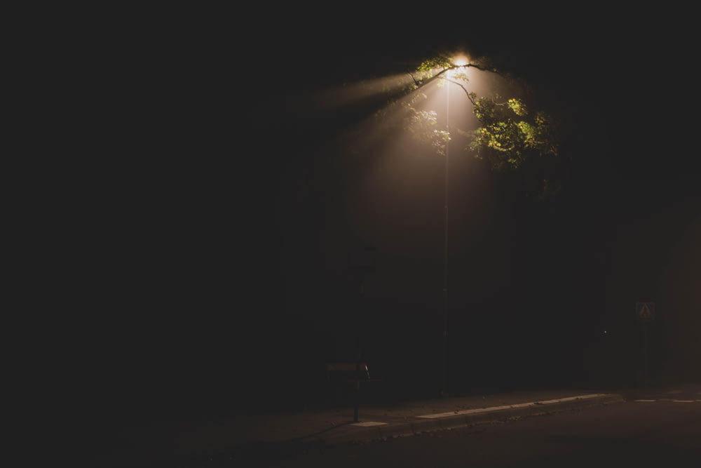 a street light shining on a dark street