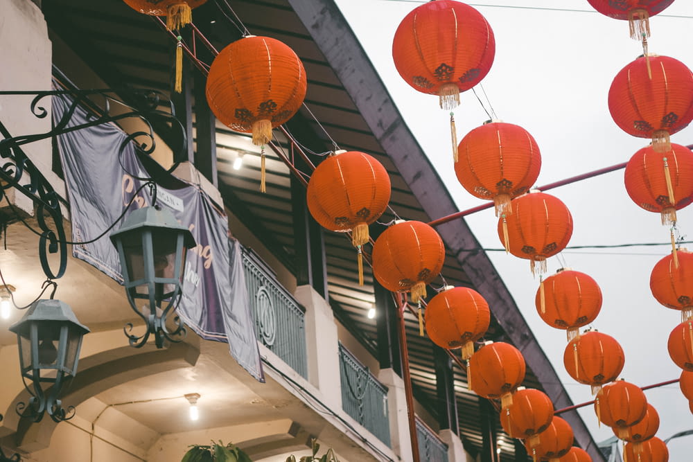 many red lanterns are hanging from a building